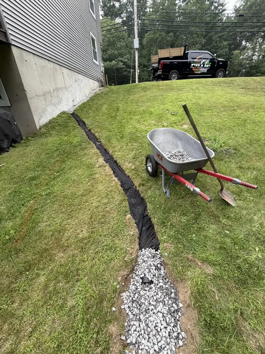Crushed stone drainage trench installed along a foundation in Southern New Hampshire