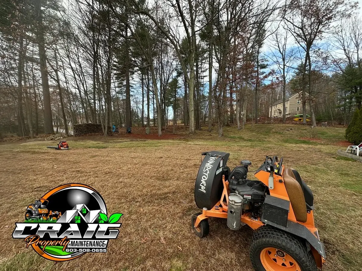 Craig Property Maintenance stand-on blower clearing a heavy spring leaf mat in Hudson NH