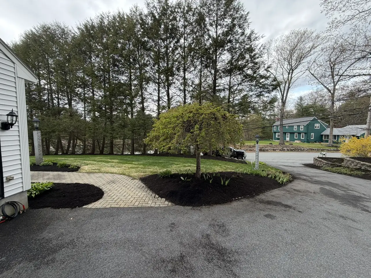 Black mulch beds lining a driveway and front walk in Southern New Hampshire