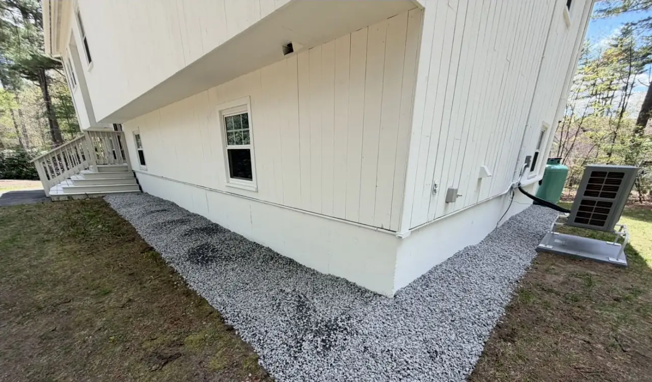Crushed stone drip edge installed along a home foundation in Southern New Hampshire