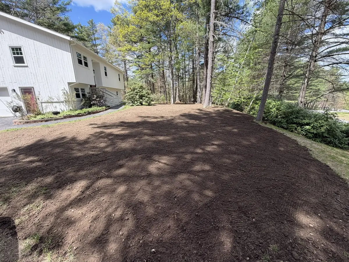 Same side yard regraded and topped with fresh screened loam, ready for seed