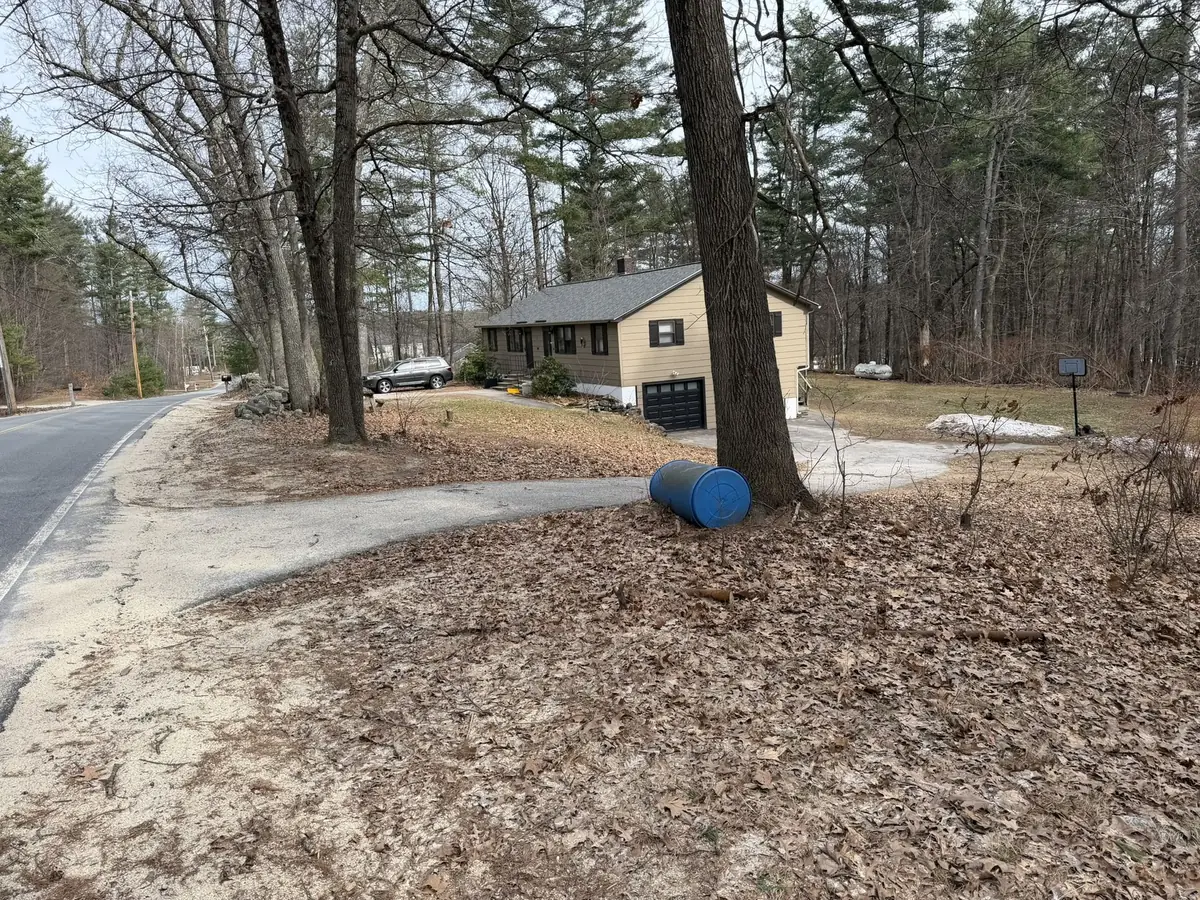 Front yard buried under matted leaves and winter debris before a spring cleanup in Southern New Hampshire