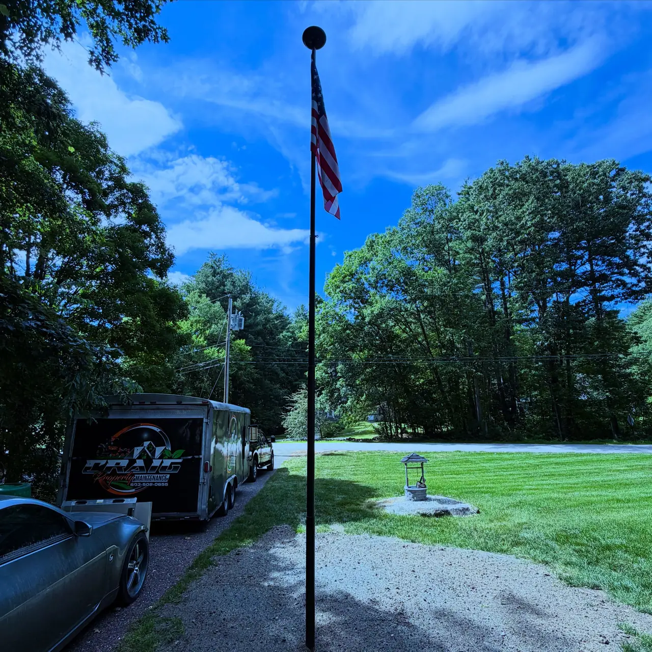 Finished flagpole installation with crushed stone base and solar light in Southern New Hampshire