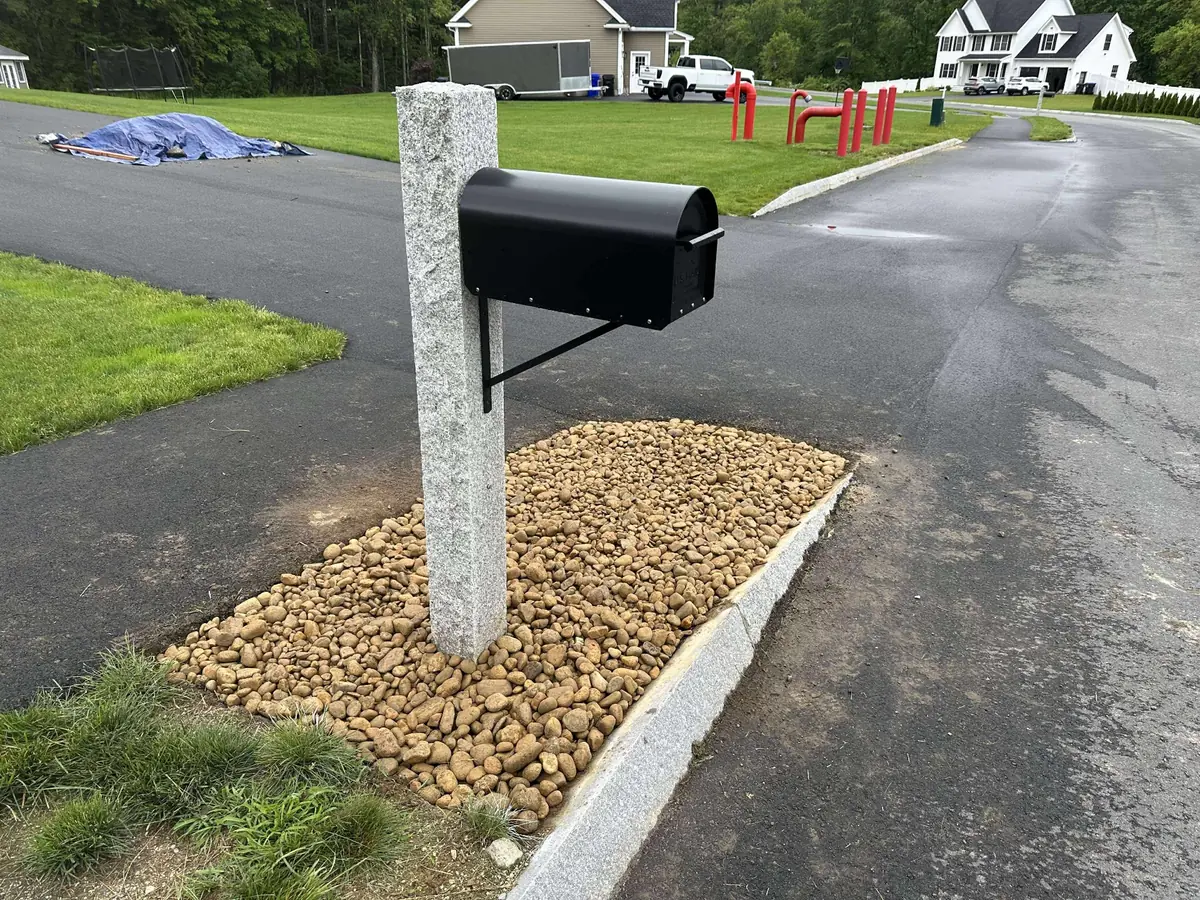 Mailbox installation in Hudson NH with granite post and river rock detail work